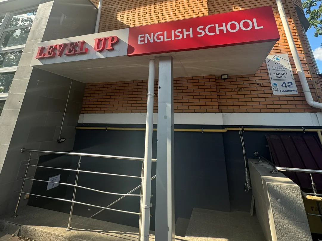 Вхід до школи англійської LevelUp в Ірпені: червона вивіска LEVEL UP ENGLISH SCHOOL над входом, вул. Павленка, 42