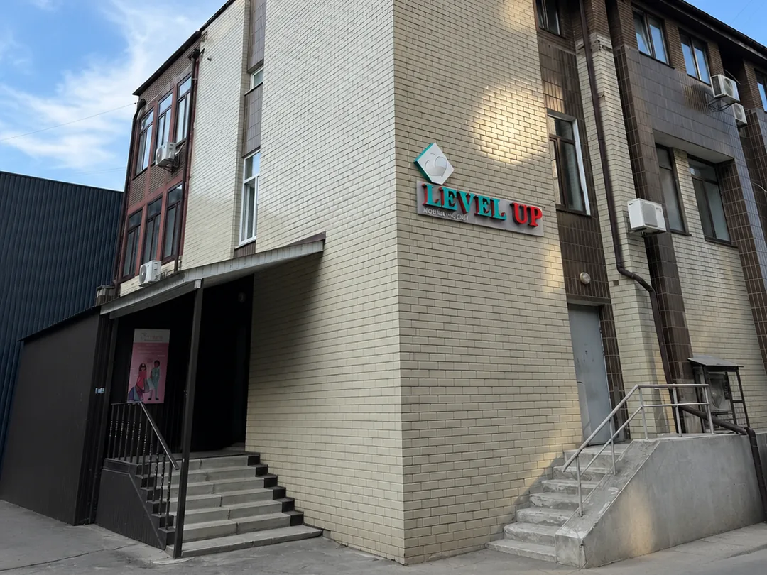Вхід до школи англійської LevelUp на Теремках: вивіска LEVEL UP на розі будівлі, ґанок зі сходами, вул. Академіка Заболотного, 20А